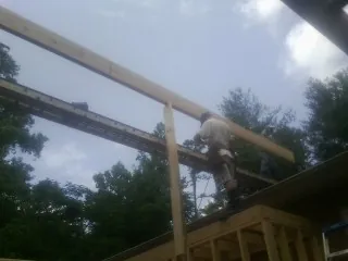 Carpenter setting a ridge beam over a new addition frame — Ice Dam Removal by Roofing Brothers in Leiters Ford